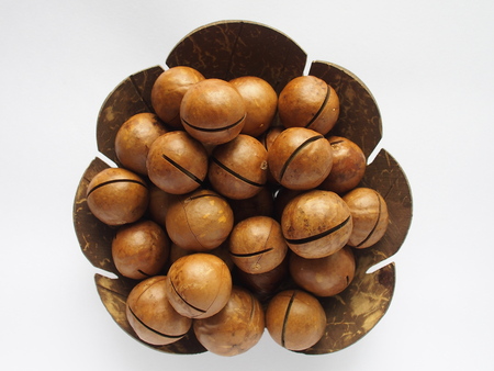 macadamia in utensil made from coconut shell on white backgroundの写真素材