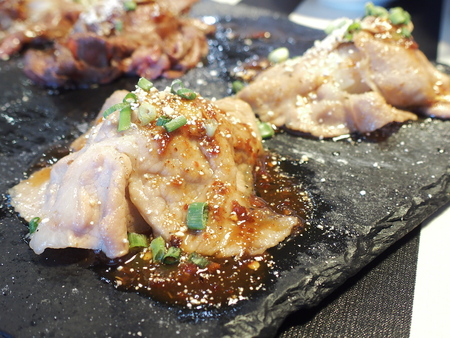 sliced pork sushi on black rectangle granite plateの写真素材