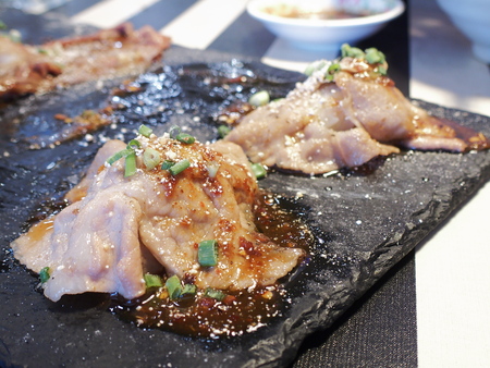 sliced pork sushi on black rectangle granite plateの写真素材