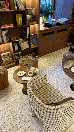 Coffee shop interior with bookcase and wicker armchairの写真素材