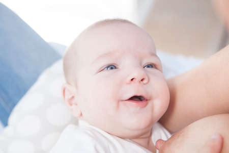 Smiling baby while he is breastfed. closeup