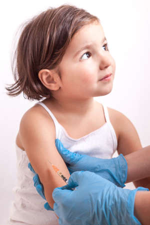 Nurse vaccinating 3 years old little girl. She is relaxed and trustingの写真素材