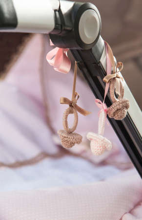 Decorative crochet pacifiers hanging on stroller barの写真素材