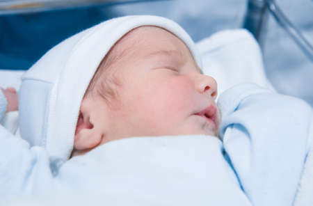 Face-up position sleeping newborn baby. Few hours-old baby at hospital cribの写真素材