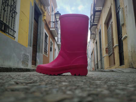 Toddler pink rainboot lost in the middle of the streetの写真素材