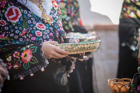 Caceres, Spain - Jan 20th, 2022: Regaoras carrying confetti and anise balls basket. Carantonas...