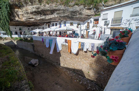 Setenil, Spain - March 4th, 2019: Street with dwellings built into rock overhangs. Setenil de las Bodegas, Cadiz, Spain. sunny caves neighborhoodのeditorial素材