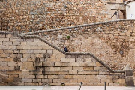 Plasencia, Spain - February 15, 2017: Man Ascending stone steps at Plasencia old town, Caceres,...