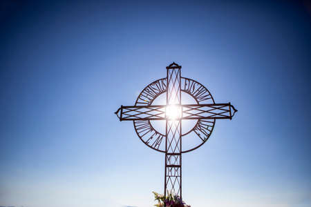 The holy cross with bright sun and blue sky in the background