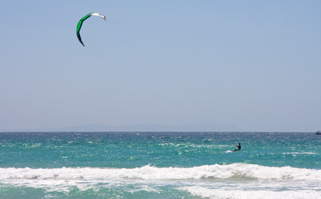 Sportsman kite surfer on clean beach in windy day, Tarifa, Spainの写真素材