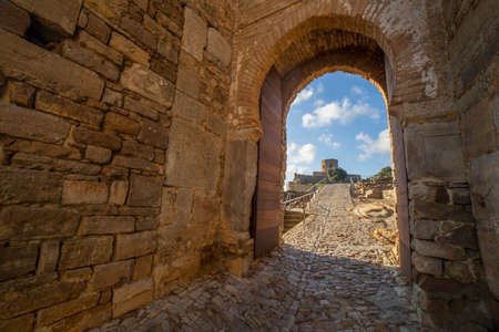 Castle of Jimena de la Frontera, Cadiz, Spain. Clock Arch and Christian Alcazar at the bottomの写真素材