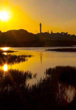 El Rompido lighthouse and marina at sunrise from marshlands, Huelva, Spainの写真素材