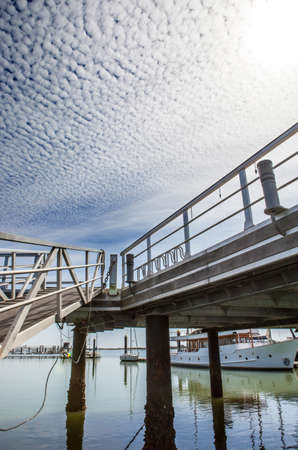 Marina footbridge with cloud formations in the sky called Altocumulus floccus, El Rompido Cartaya, Huelva, Spainの写真素材