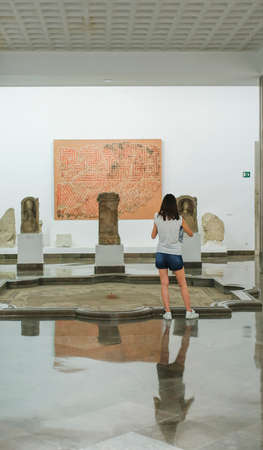 Seville, Spain - July 7th, 2018: Young woman visiting Archeological museum of Seville, Andalusia,...