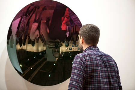 Madrid, Spain - Feb 26 2017. The contemporary art fair, ARCO, opens in Madrid. Visitor observing work made with mirrorのeditorial素材
