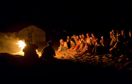 ZAGORA, MOROCCO - JUNE 14: Group of tourists dancing and singing around the fire, on June 14, 2010, Zagora, Moroccoのeditorial素材