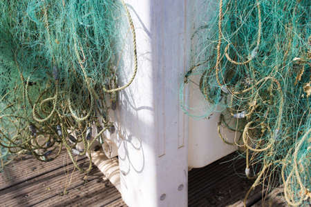 Plastic container full of green nylon fishing nets at fishing port. Cabins of Tavira, Portugal