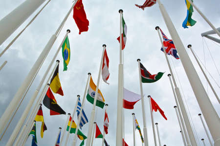 Flags of all nations of the world are flying in gray cloudy skyの写真素材