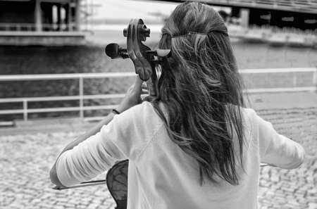 Street girl musician playing on violoncello, Lisbon, Portugalの写真素材
