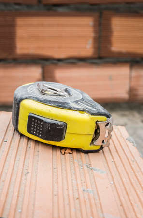 Measuring tape over clay-based bricks. closeupの写真素材