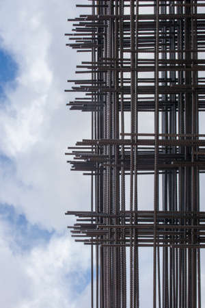 Reinforcing bars framework for armored concrete construction. Blue cloudy sky