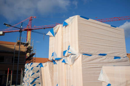 Extruded polystyrene foam packs at construction site. Cranes at bottom