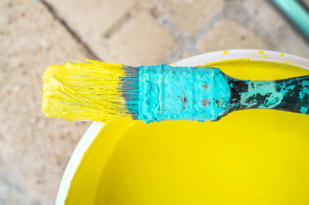 Used flat decorator brush covered with dry cyan and wet yellow color. closeupの写真素材