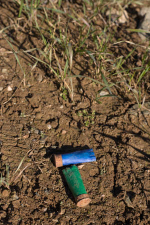 Rusty spent shotgun cartridges on a meadow floor. This is a bad behavior of many hunters in Spain