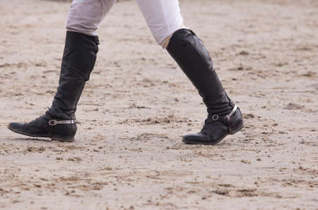 Rider walking a course at horse jumping competition. Boots detailsの写真素材