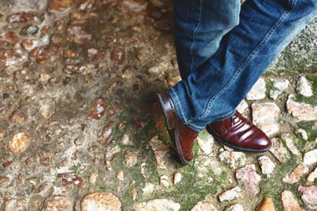Man legs with burgundy shoes over stony floorの写真素材