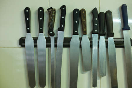Set of baking knives hang on the wall. magnetic knife rack