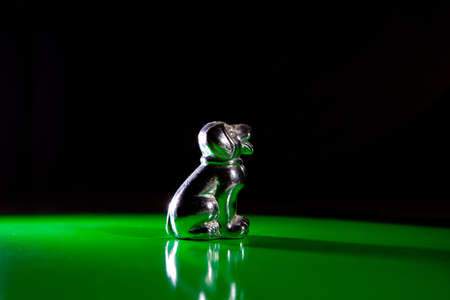 Silver little dog figurine isolated over green backgroundの写真素材