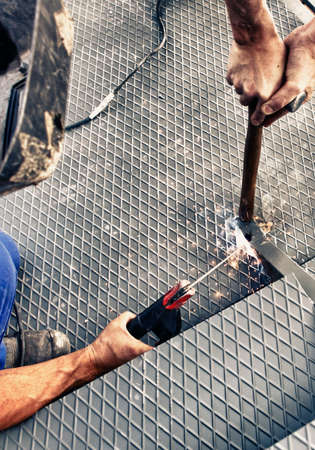 Two men working on iron platform with arc weldingの写真素材