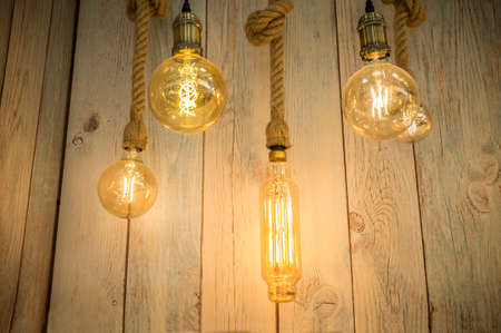 Rope light bulbs over weathered wooden background. low-angle view