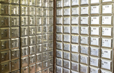 Corner full of rows of old shiny metal post office boxesの写真素材