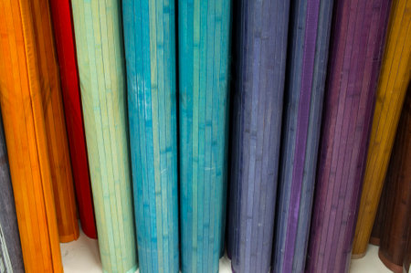 Loads of many rolled colorful bamboo carpets. closeup