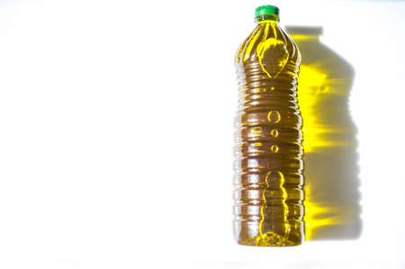 Olive oil bottled in PET with golden reflections. isolated over whiteの写真素材