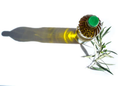 Olive oil bottled with young olives branch. isolated over white