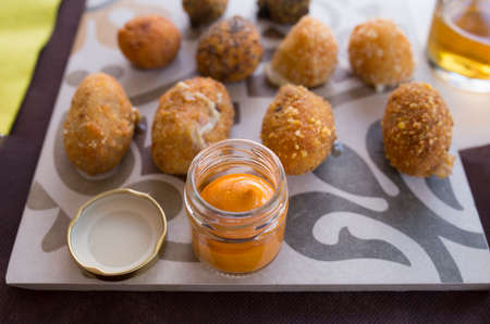 Assorted croquettes sauce served on cement tile. Selective focus