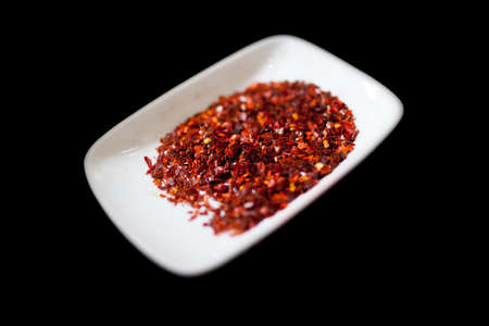 Smoked Paprika of Jaraiz in flakes. isolated on black