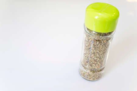 Glass bottle of dry oregano leaves. closeupの写真素材