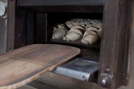 Oven inside plenty of half-baked bread. Manufacturing process of spanish bread