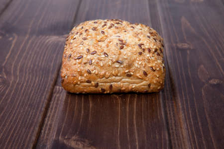 Fresh, squared wholemeal bread with sunflower seeds, sesame and other grains. Isolated over dark...