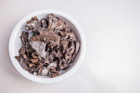 White bowl full of Horn of Plenty mushrooms. isolatedの写真素材