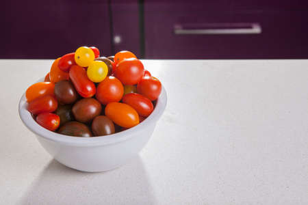 Clay bowl full of several varieties of cherry tomatoes. studio takeの写真素材