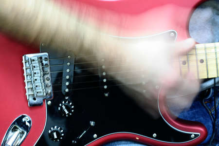 Electric guitar close up with hand playing itの写真素材