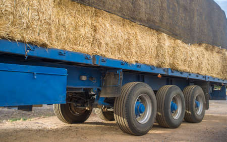 Heavy trailer truck loaded with straw bales. closeupの写真素材