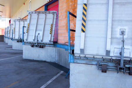 Truck loading docks at commercial building. Overhead door, dock leveler, and dock seals