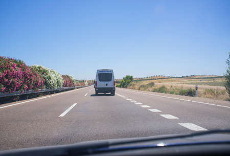 Driving behind ambulance on highway. View from inside the carの写真素材