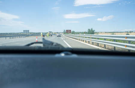 Roadworks on a highway divert traffic to a temporary road. View from inside the carの写真素材